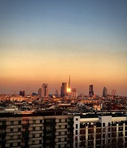 Buildings in city at sunset