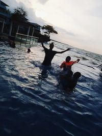 People enjoying in sea against sky