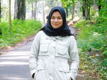 Portrait of young woman standing in forest