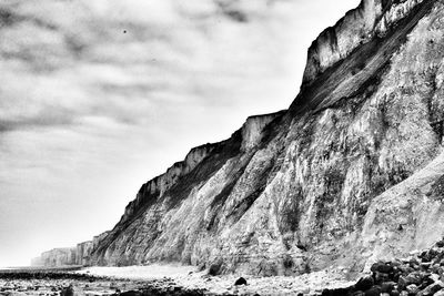 Rock formations on beach against sky