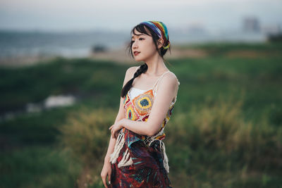 Young woman standing against sky