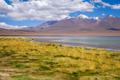 Scenic view of lake by mountains against sky