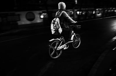 Man riding bicycle on street in city