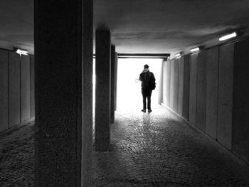 Rear view of man standing in underground walkway