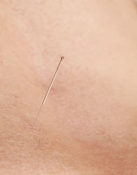 Close-up of needle in human skin