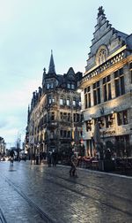 People walking on street amidst buildings in city