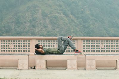 Rear view of men sitting on sidewalk