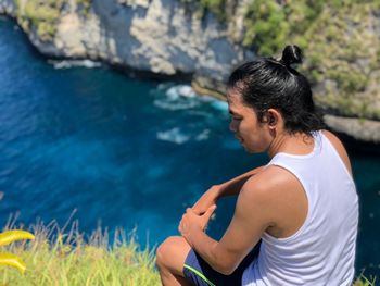 Man on rock by sea