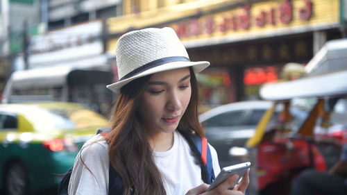 Young woman looking away while using mobile phone