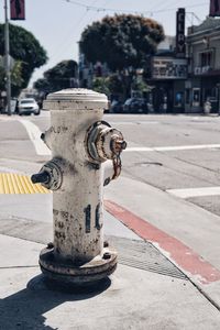 Close-up of fire hydrant on sidewalk in city during sunny day