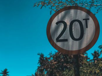 Road sign against blue sky