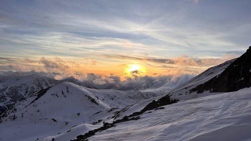 Scenic view of snowcapped mountains against sky during sunset