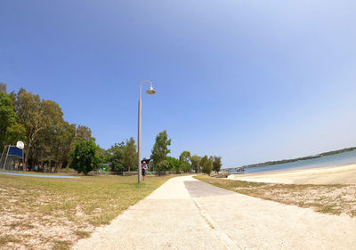 Street by sea against clear sky