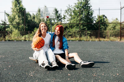 A couple of teenage girls on a sports street court with a basketball lifestyle 