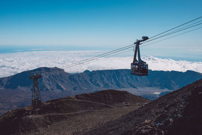 Overhead cable car on snowcapped mountains against sky