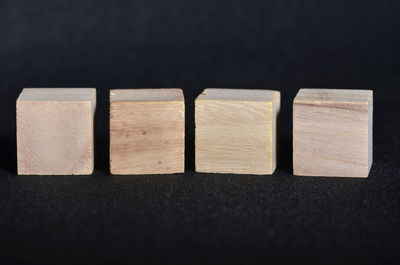 Close-up of wooden blocks over black background