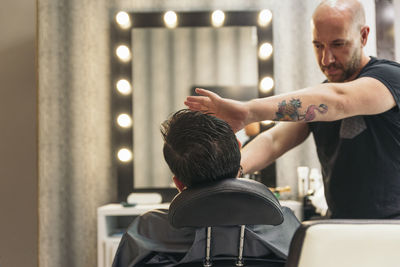 Barber shaving man at salon