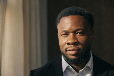 Portrait of young man standing against wall