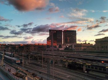 Railroad track against cloudy sky at sunset