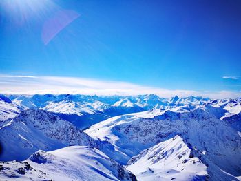 Scenic view of snowcapped mountains against blue sky