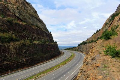 Road leading towards mountains against sky