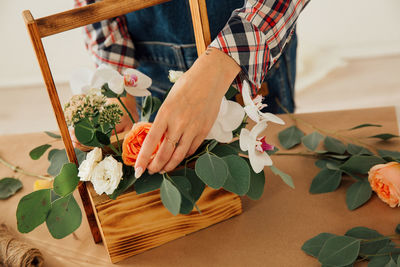 Midsection of woman holding bouquet of red roses