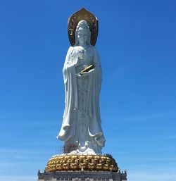 Low angle view of statue against blue sky