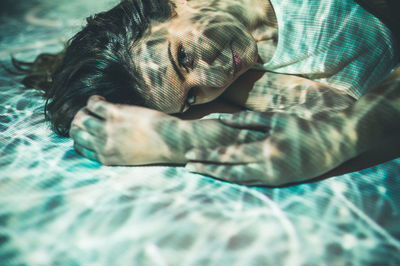 High angle portrait of woman relaxing on bed