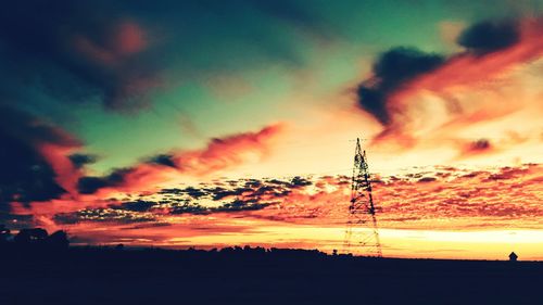 Low angle view of silhouette trees against dramatic sky