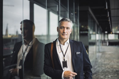 Portrait of entrepreneur leaning on glass window in office