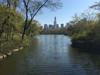 Scenic view of river by buildings against clear sky