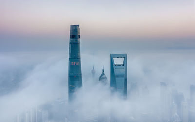 Modern buildings against sky during sunset