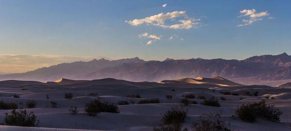 Scenic view of sand dunes against sky during sunset