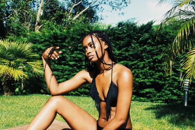 Woman sitting on grassy field in park