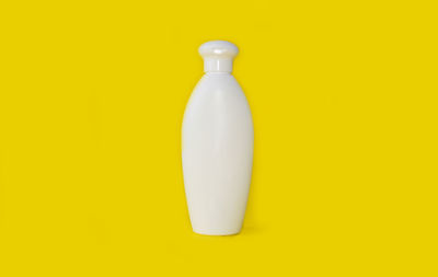 Close-up of bottle against yellow background