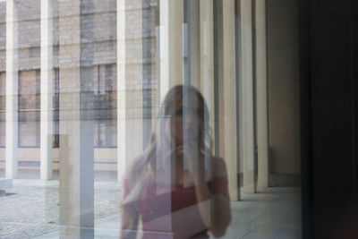 Woman sitting on glass window