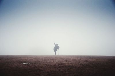 Rear view of woman standing on landscape