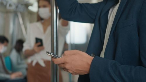 Midsection of man using mobile phone