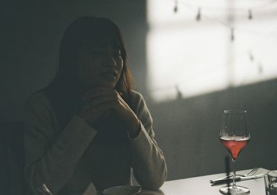 Man drinking glass on table