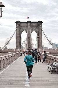 Rear view of woman jogging on brooklyn bridge