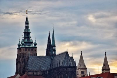 Buildings in city against cloudy sky