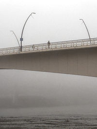Silhouette on bridge on a foggy day
