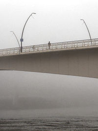 Silhouette on bridge on a foggy day