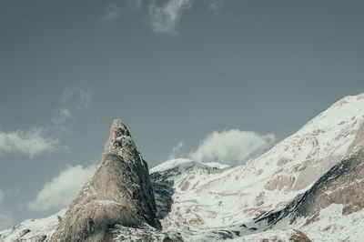 Low angle view of snowcapped mountain against sky