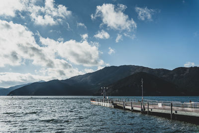 Scenic view of sea and mountains against sky