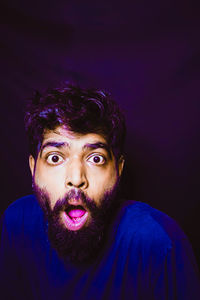 Portrait of young man against black background