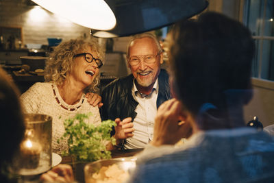 Cheerful senior friends enjoying dinner party at home