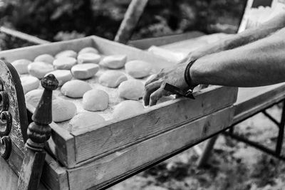 Cropped hand of man preparing food outdoors