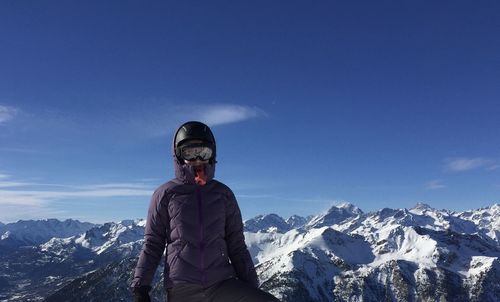 Man standing on snowcapped mountain against sky