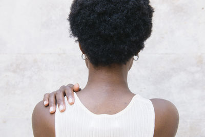 Rear view of woman standing against wall